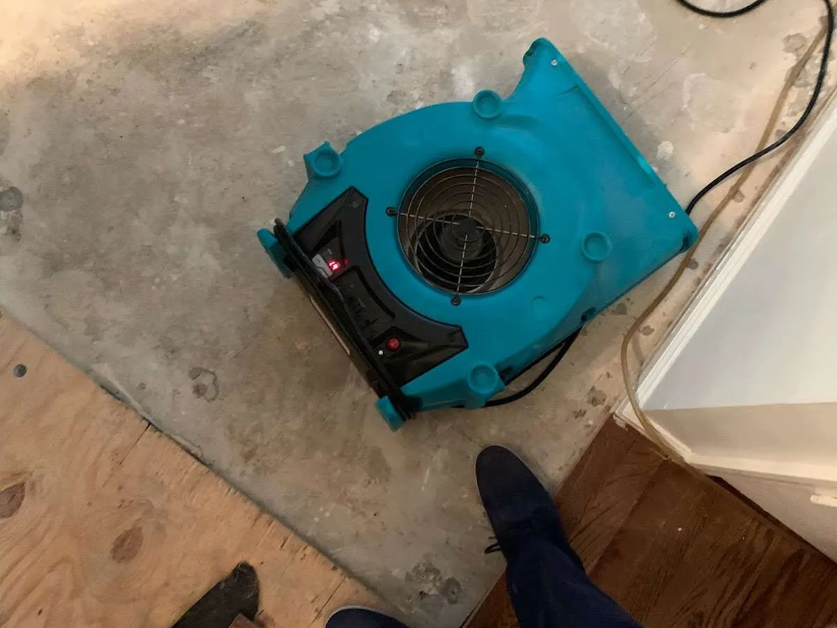 Air mover drying subfloor during Commercial Water Damage Restoration in East Vincent